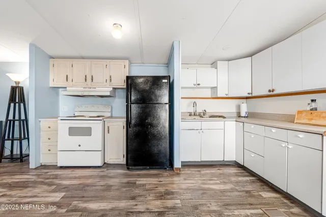 a kitchen with white cabinets and white appliances