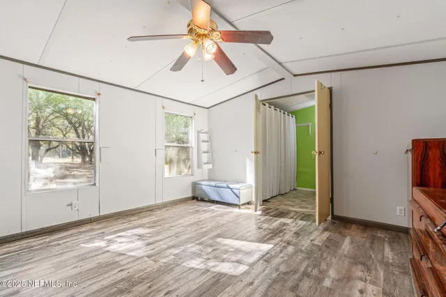 a view of empty room with window and wooden floor