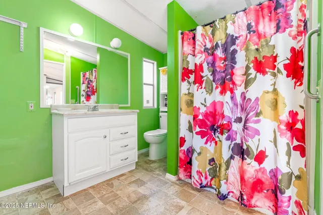 a bathroom with a sink mirror vanity and toilet