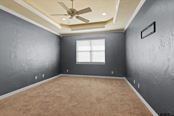 an empty room with windows and fan