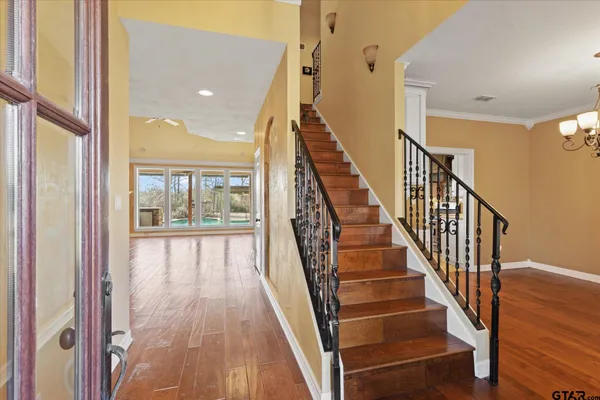 a view of staircase with wooden floor and a large window