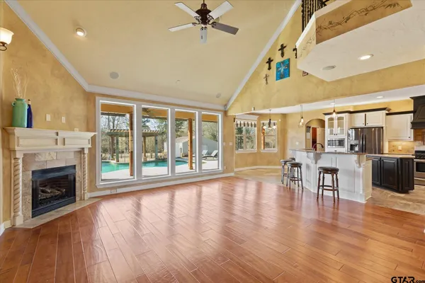 a view of an empty room with wooden floor and a fireplace