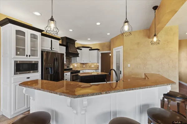 a kitchen with stainless steel appliances granite countertop a sink and a refrigerator