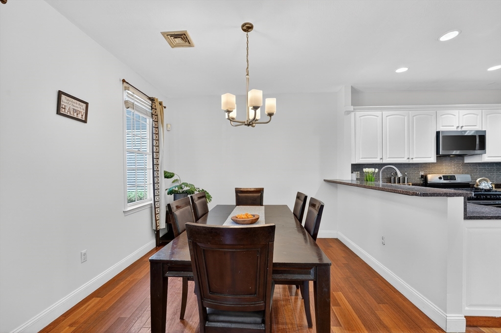 15 Evergreen Circle, Unit 15 Canton, MA 02021 - Photo 12 of 29 a view of a dining room with furniture a chandelier and wooden floor