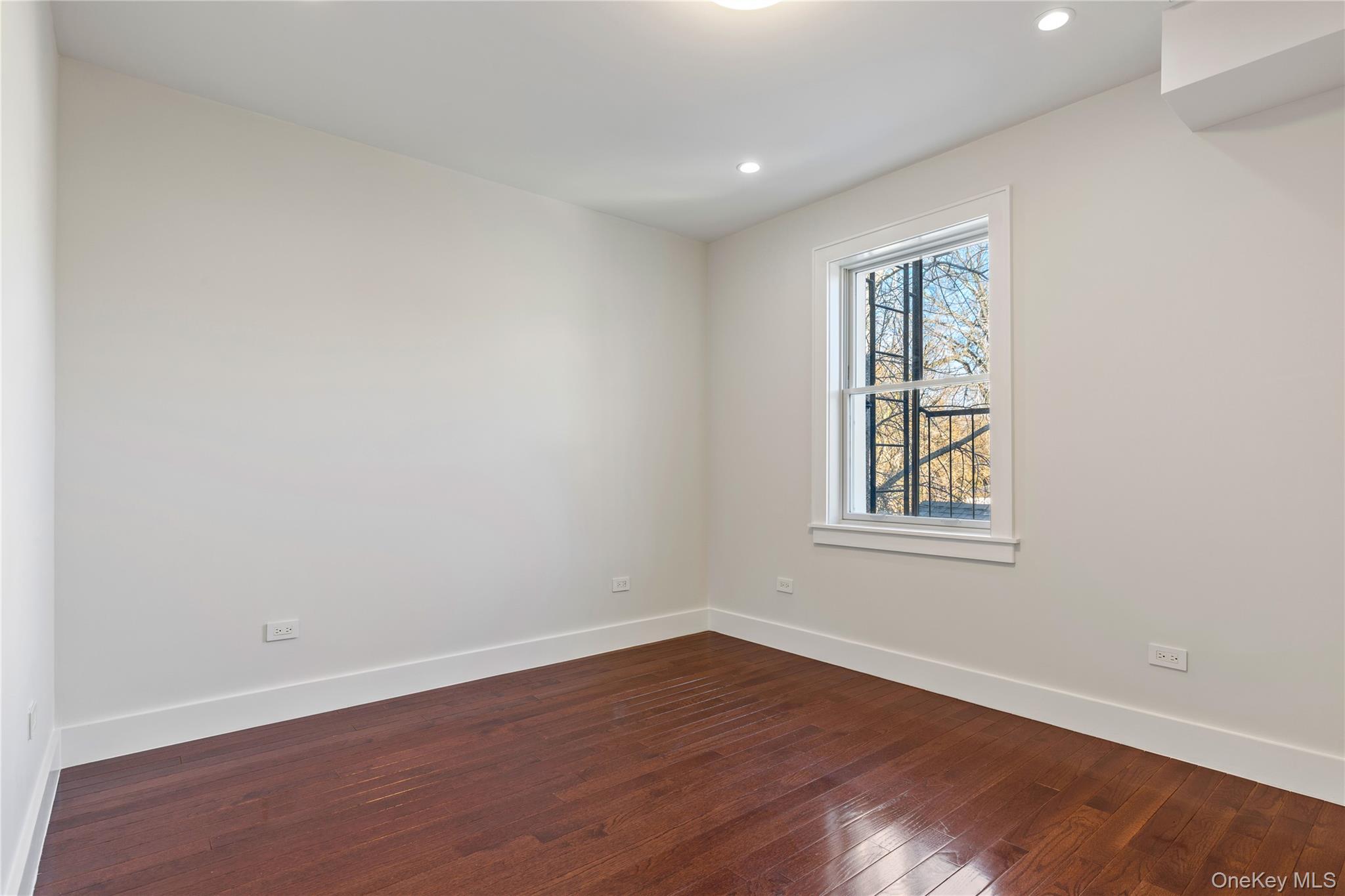385 Midland Avenue, Unit 2 Rye, NY 10580 - Photo 13 of 20 an empty room with wooden floor and windows