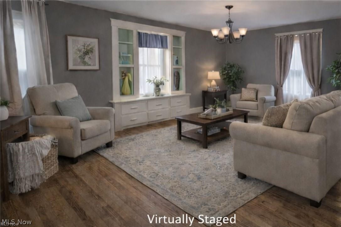1911 Youngstown Road Southeast Warren, OH 44484 - Photo 4 of 17 Living room with a chandelier and dark wood-type flooring