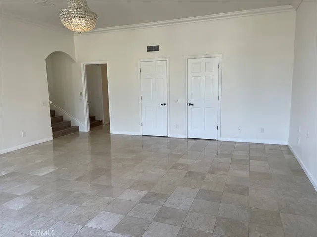 a view of an empty room and a kitchen