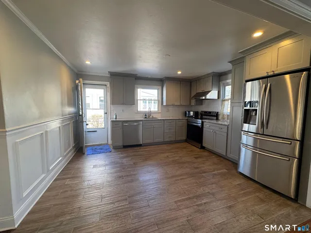 a kitchen with stainless steel appliances granite countertop a refrigerator sink and stove