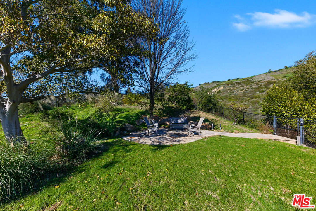 6070 Ramirez Canyon Road Malibu, CA 90265 - Photo 20 of 42 a view of a chairs and table in a yard