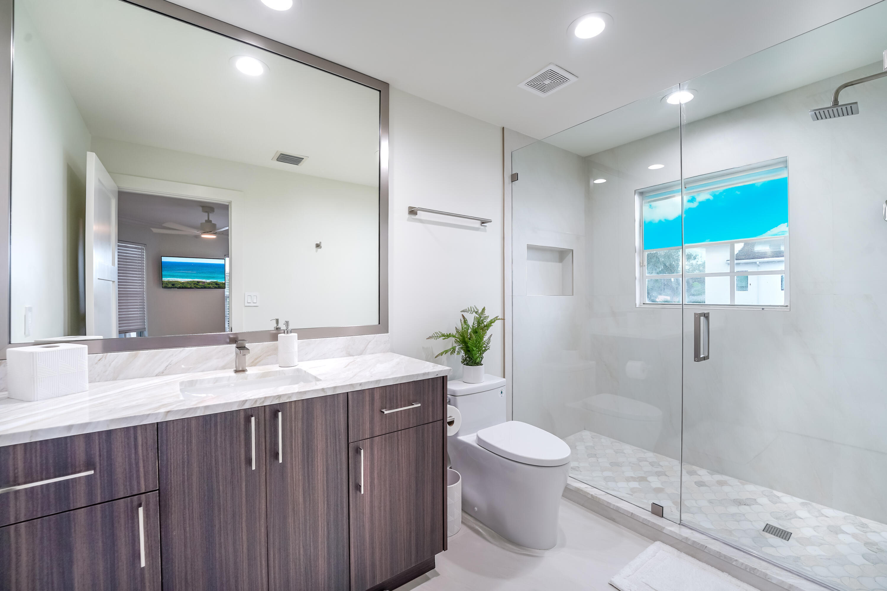749 Northeast 71st Street Boca Raton, FL 33487 - Photo 34 of 43 a bathroom with a granite countertop sink a toilet a mirror and shower