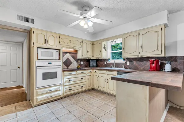 a kitchen with cabinets appliances and a window