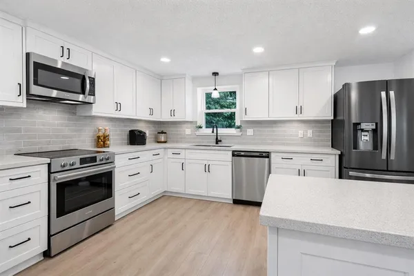 a kitchen with stainless steel appliances granite countertop a stove a sink and a refrigerator