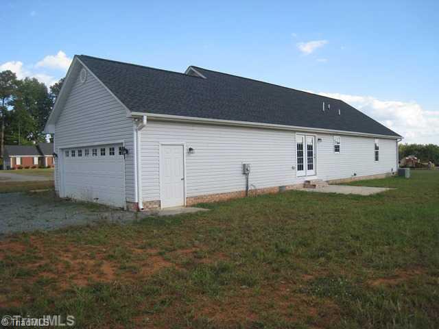 3435 Boywood Road Graham, NC 27253 - Photo 16 of 16 Exterior Back. Pedestrian Door to Garage. Back Patio off of Kitchen.