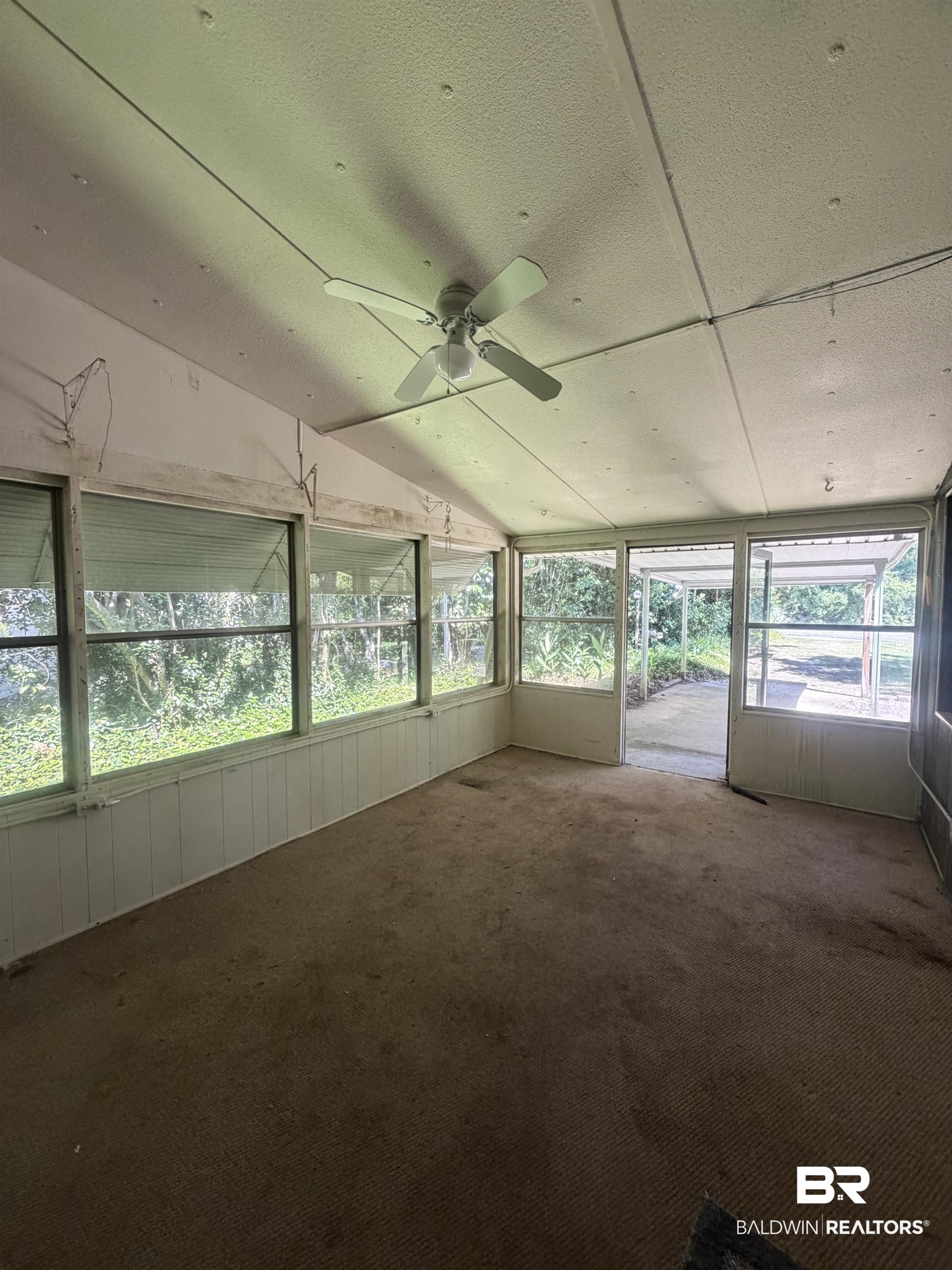 1354 Caney Loop Lillian, AL 36549 - Photo 4 of 45 Enclosed screened porch with a ceiling fan, carpet flooring, and white paneling