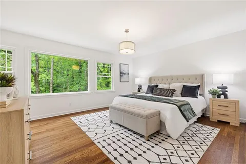 an empty room with wooden floor and fan