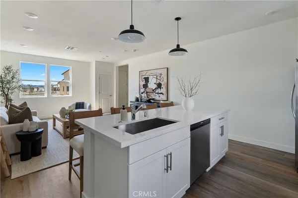 a kitchen that has a sink a stove and a wooden floor