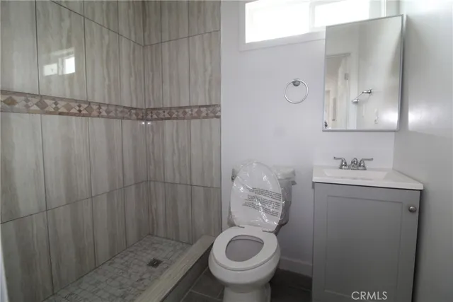 a bathroom with a sink and mirror with toilet