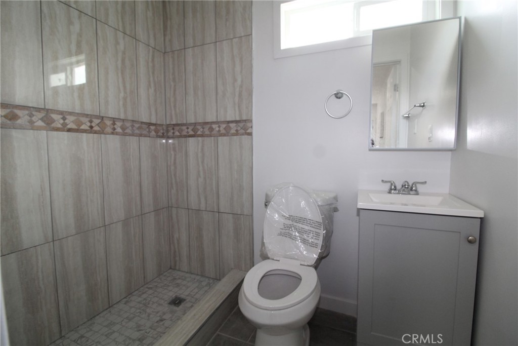 4954 Tweedy Boulevard, Unit F South Gate, CA 90280 - Photo 6 of 12 a bathroom with a sink and mirror with toilet