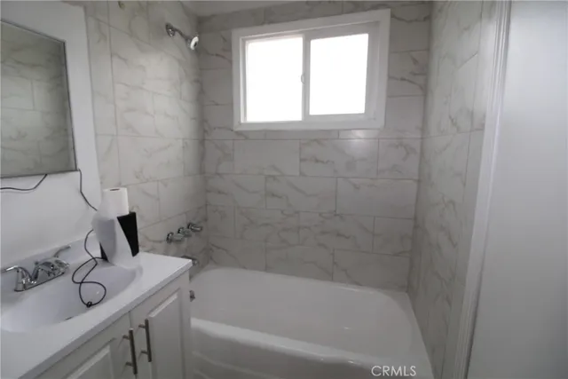 a bathroom with a bathtub sink vanity and window