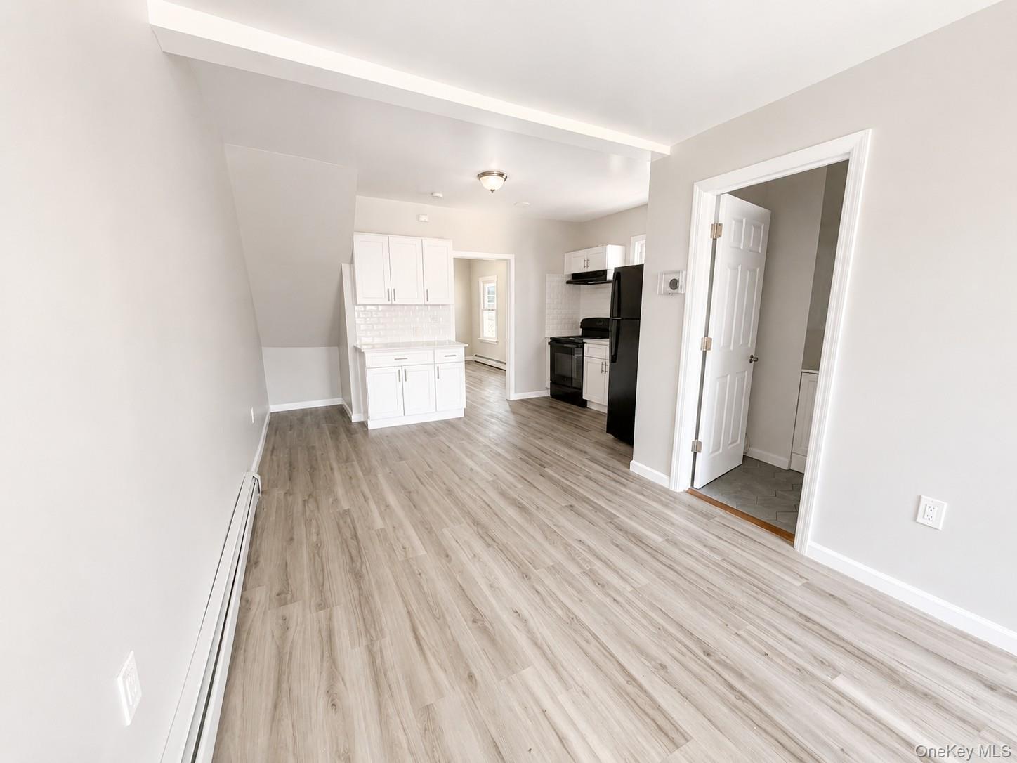 25 Monroe Street, Unit 1 Mount Vernon, NY 10550 - Photo 2 of 11 Open concept living area featuring wood-finish flooring, light gray wall tones, and white baseboards