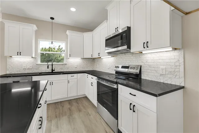 a kitchen with a sink stove and microwave