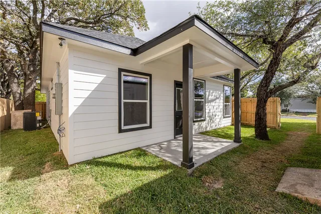 an empty room with wooden floor chandelier fan and windows