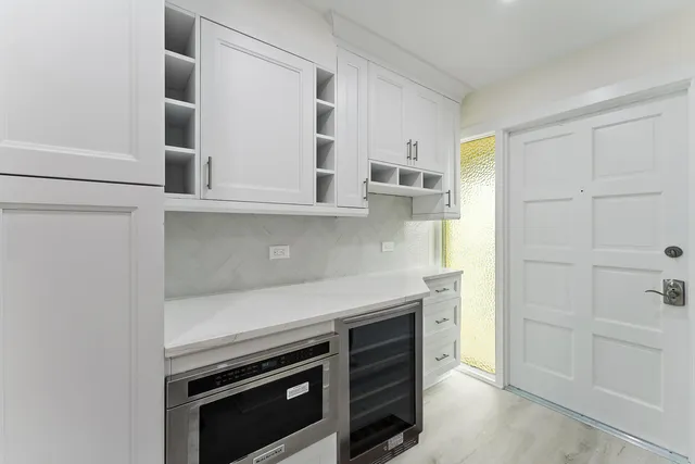 a kitchen with stainless steel appliances kitchen island granite countertop a refrigerator and a sink