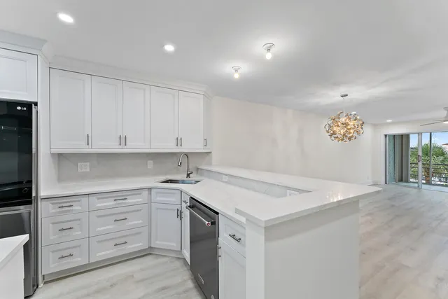 a kitchen with granite countertop white cabinets white appliances and a sink