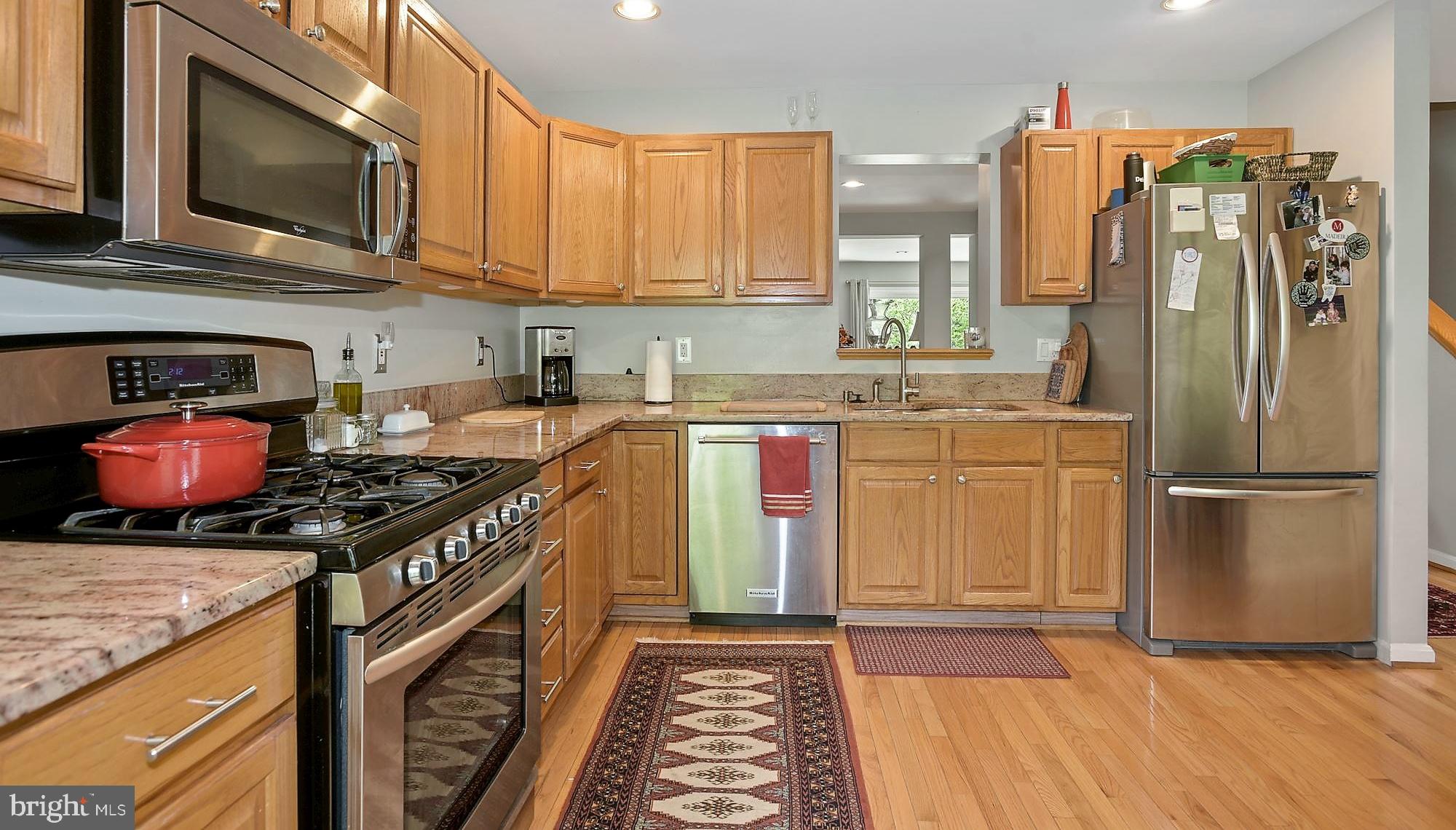 12062 Edgemere Circle Reston, VA 20190 - Photo 5 of 29 a kitchen with stainless steel appliances granite countertop a stove top oven a sink dishwasher and a microwave oven with cabinets