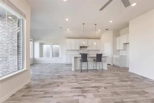 a view of an empty room with a fireplace and a window