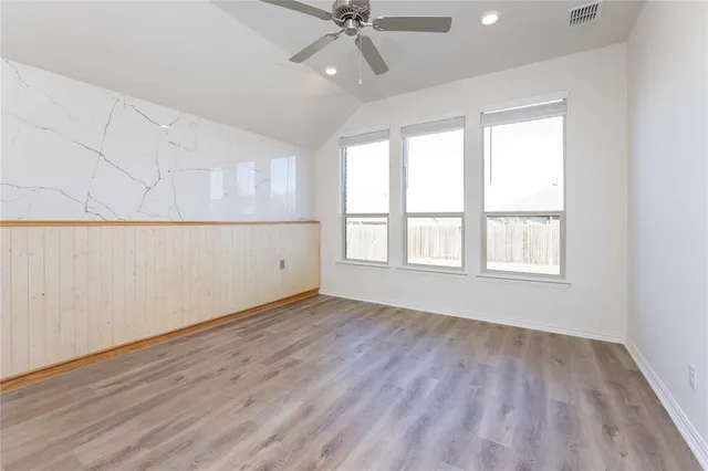 a living room with stainless steel appliances kitchen island granite countertop a dining table chairs and a two windows