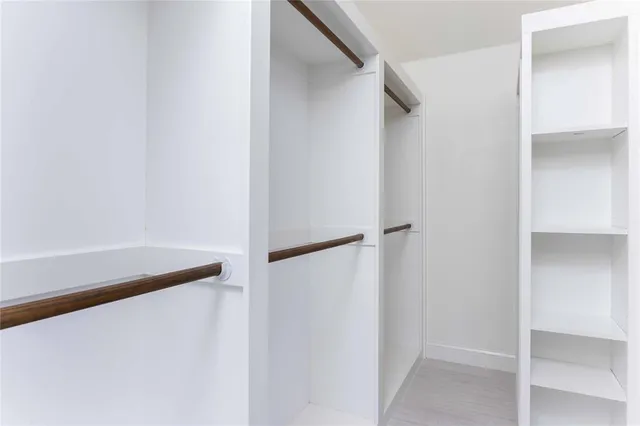 a view of walk in closet with empty racks