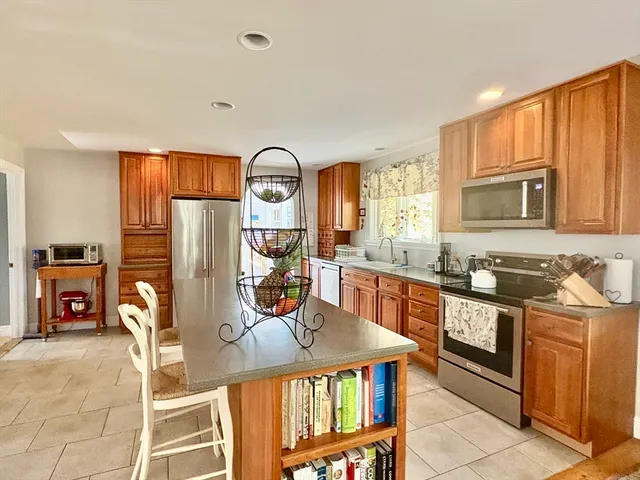 a kitchen with stainless steel appliances granite countertop a stove a sink and a refrigerator