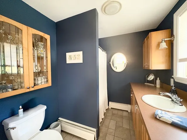 a bathroom with a toilet sink vanity granite and mirror