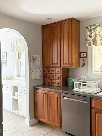 a kitchen with stainless steel appliances a sink a stove a refrigerator cabinets and a window