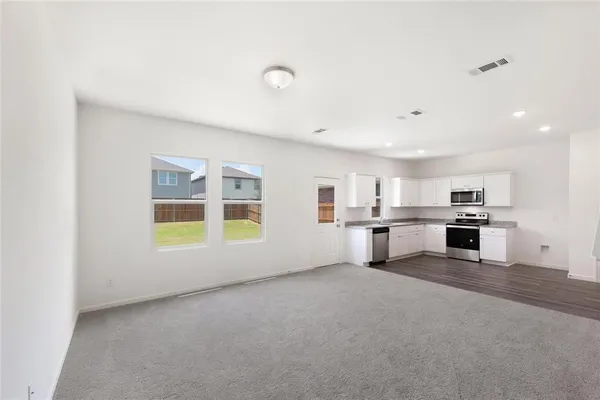 a view of empty room with kitchen and sink