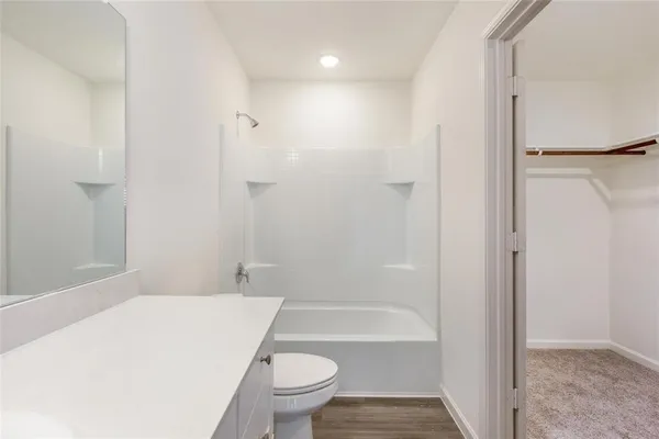 a bathroom with a granite countertop toilet a sink and bathtub