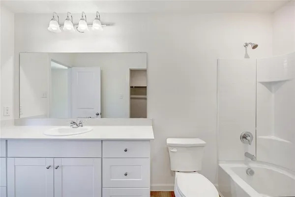 a bathroom with a sink mirror vanity and toilet