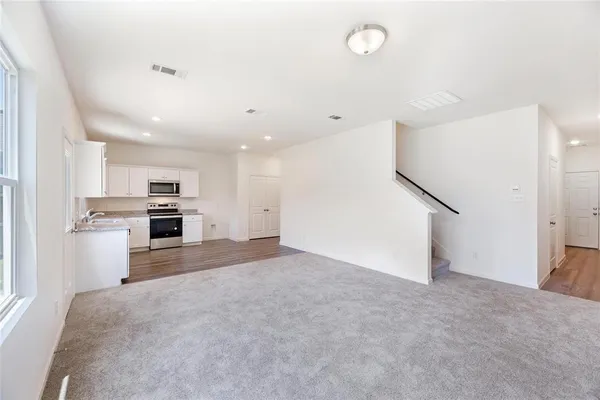 a view of a kitchen with a sink and dishwasher a refrigerator with white cabinets