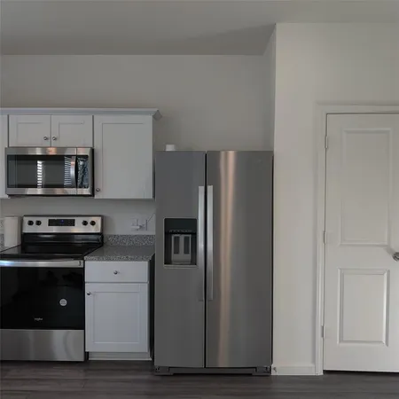 a kitchen with stainless steel appliances granite countertop a refrigerator and a stove top oven