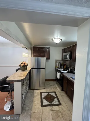 a kitchen with refrigerator and chairs