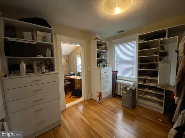 a view of walk in closet with clothes and shoes