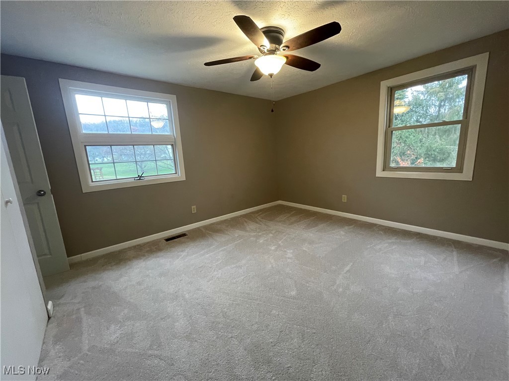 1984 Hebron Road St. Marys, WV 26170 - Photo 20 of 33 Spare room with light colored carpet, ceiling fan, baseboards, and a textured ceiling