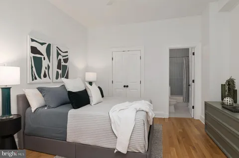 a bedroom with a bed and wooden floor