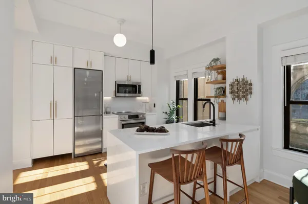 a kitchen with stainless steel appliances a microwave a stove a refrigerator and a sink