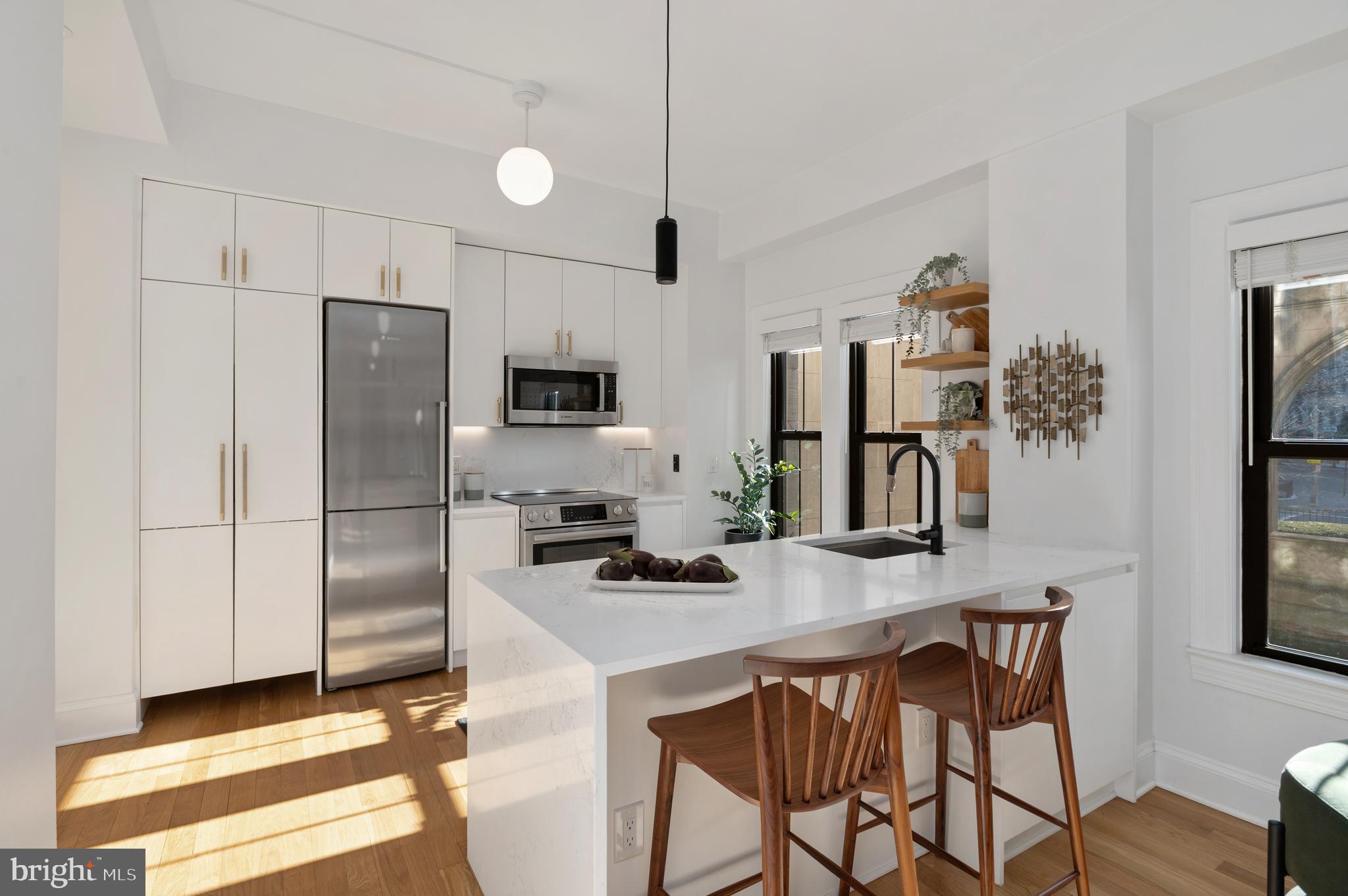 1613 Harvard Street Northwest, Unit 102 Washington, DC 20009 - Photo 4 of 27 a kitchen with stainless steel appliances a microwave a stove a refrigerator and a sink