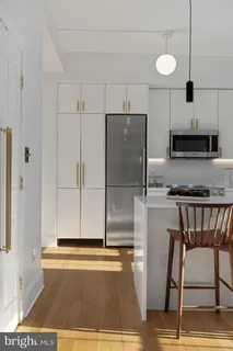 a kitchen with granite countertop a refrigerator and a stove top oven
