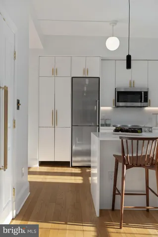 a kitchen with granite countertop a refrigerator and a stove top oven