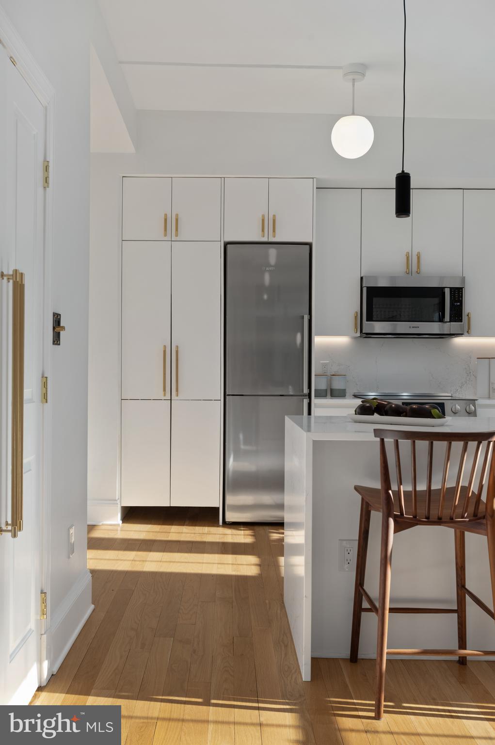 1613 Harvard Street Northwest, Unit 102 Washington, DC 20009 - Photo 7 of 27 a kitchen with granite countertop a refrigerator and a stove top oven