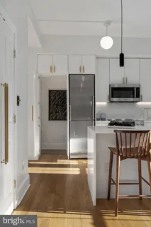 a kitchen with kitchen island a counter top space a sink and a refrigerator